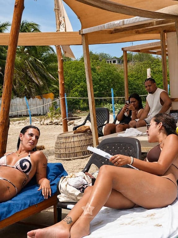 Grupo de amigos compartiendo en los camastros a la sombra, en el pasadía a Playa Linda