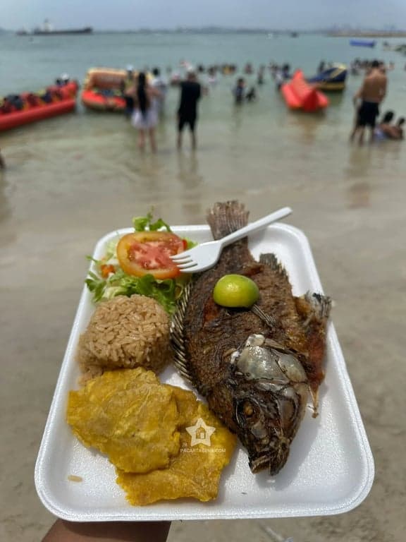 Almuerzo frente a la playa de Punta Arena, con bañistas y flotadores al fondo