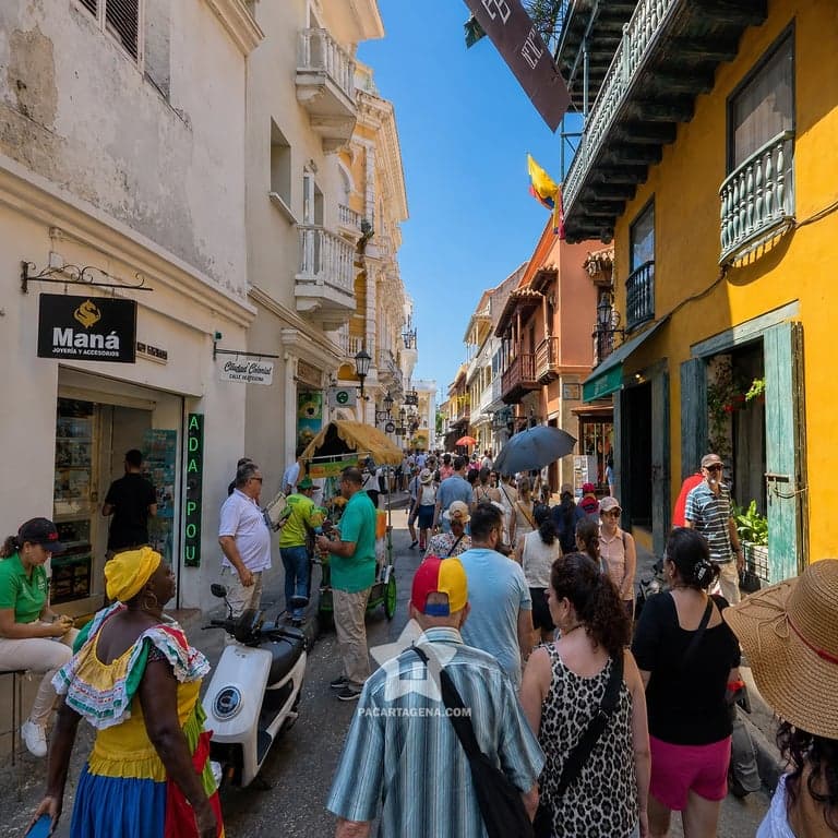 Calle colonial del Centro Histórico de Cartagena con balcones y una palenquera de frutas