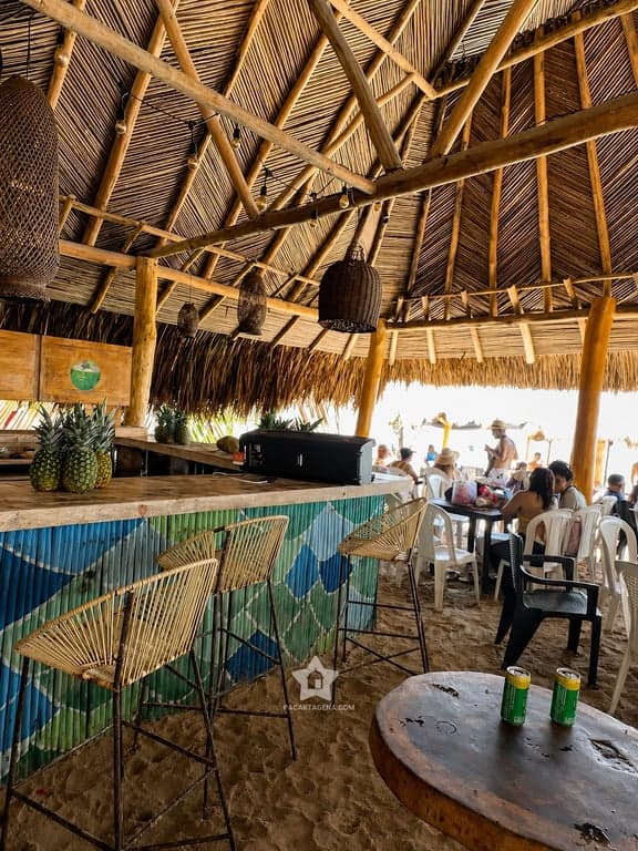 Comedor bajo techo de palma con barra en Bongo, Punta Arena: mesas y sillas para el almuerzo