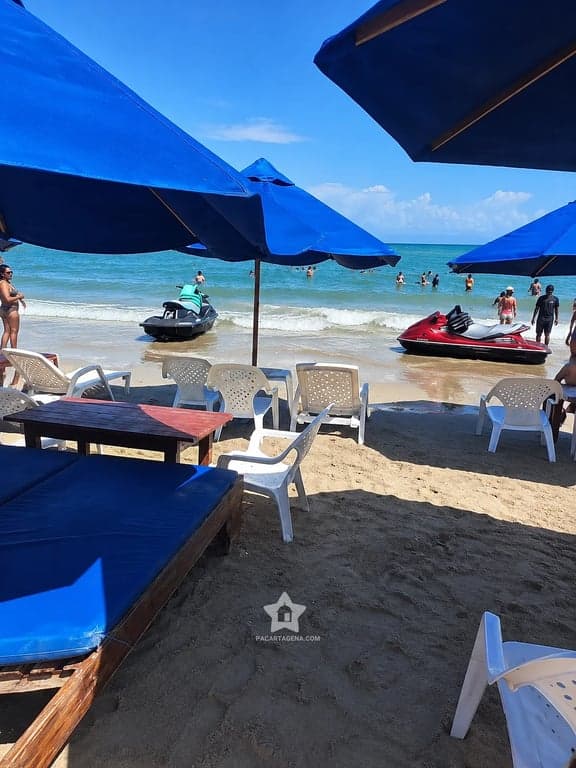 Zona de sombrillas de Playa Linda con motos de agua sobre el mar de Tierra Bomba