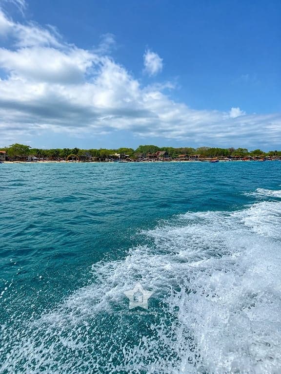 Playa Blanca de Barú vista desde el mar, con lanchas y quioscos en la orilla