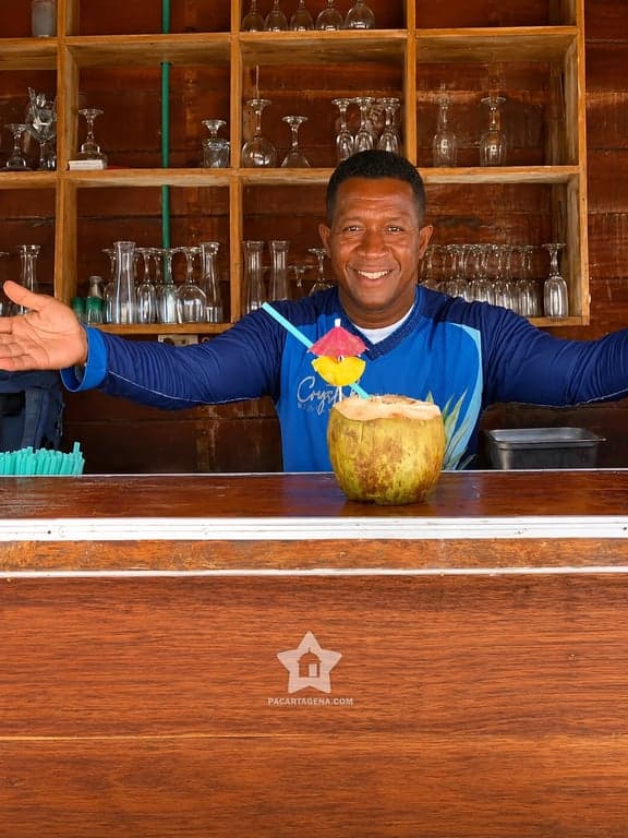 Atención en el bar de la isla con agua de coco fresca, servicio del pasadía en el Rosario