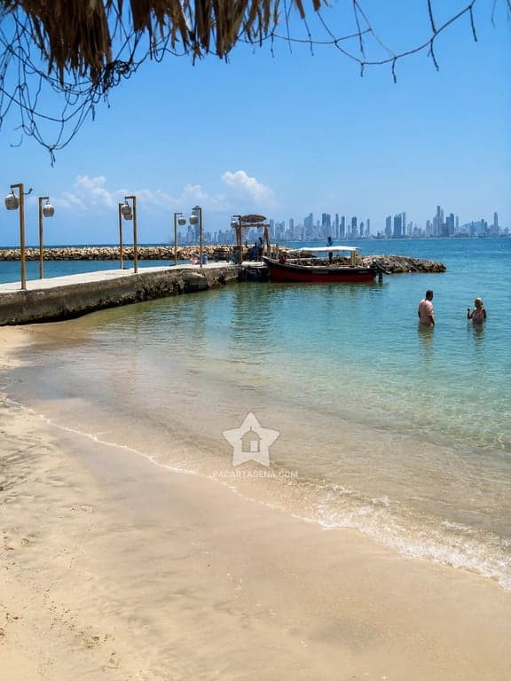 Playa y muelle de Tierra Bomba con el perfil de Cartagena al otro lado de la bahía