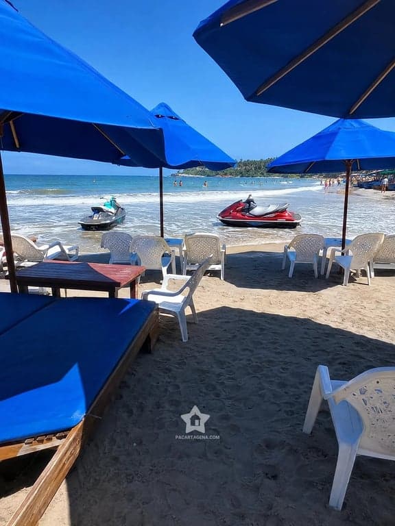 Sombrillas azules y camastros frente al mar en Playa Linda, Tierra Bomba