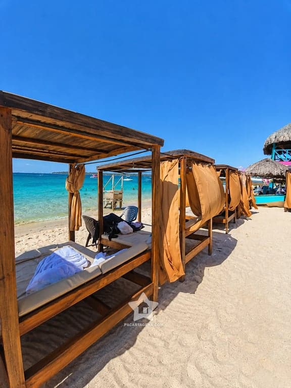 Camas de descanso frente al mar turquesa en una isla del Rosario, zona de relax del pasadía