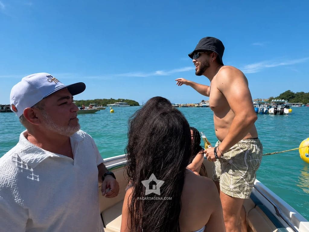 Grupo de familia y amigos a bordo en la ensenada de Cholón, rodeados de botes anclados