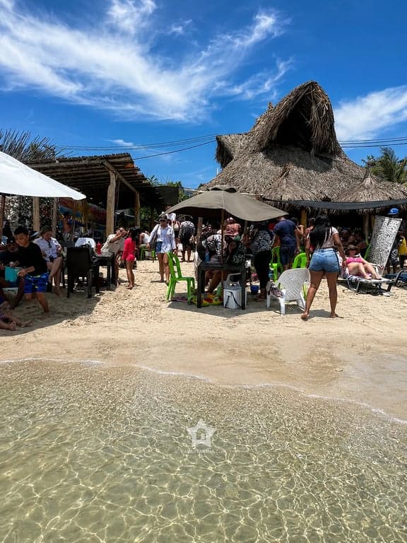 Zona de kioscos y sillas de Punta Arena con visitantes disfrutando el día de playa