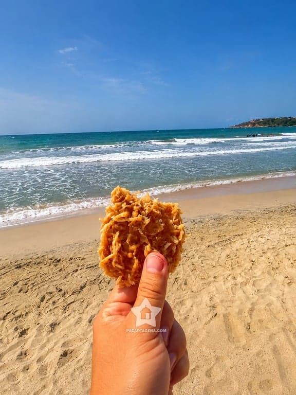 Frito típico de la costa en la mano frente al mar de Tierra Bomba