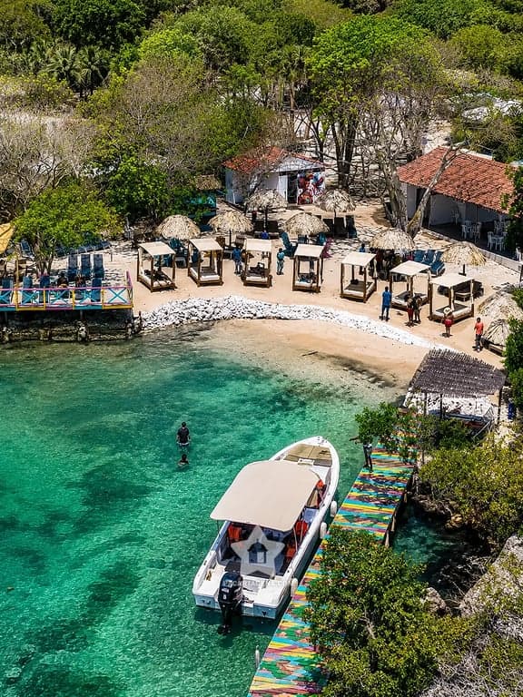 Cala turquesa de las Islas del Rosario con muelle de colores y lancha, tour 4 islas desde Cartagena