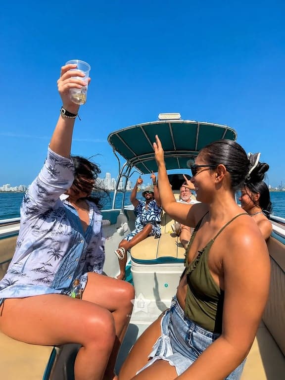 Amigos a bordo del bote privado saliendo de Cartagena, con los edificios de la ciudad al fondo