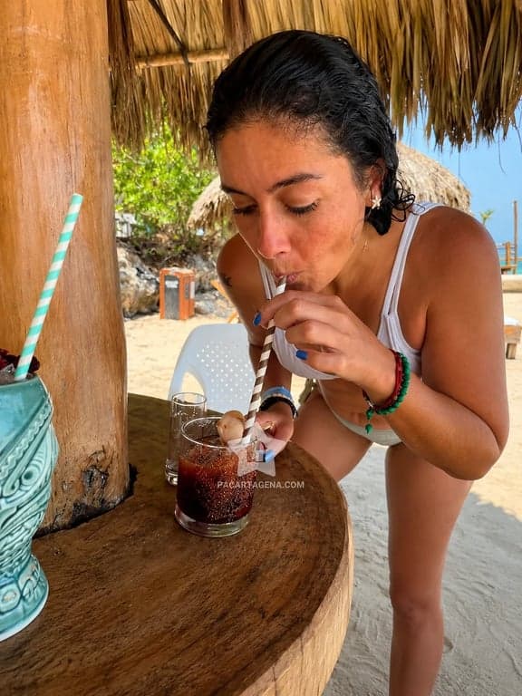 Bebida en una mesa del club de playa, bajo el techo de palma en Tierra Bomba