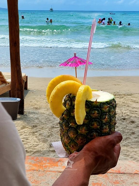 Cóctel servido en piña frente al mar de Playa Linda: la bienvenida del pasadía en Tierra Bomba