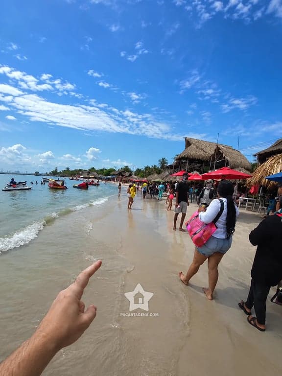 Ambiente de playa con sombrillas y bañistas en Punta Arena, Tierra Bomba