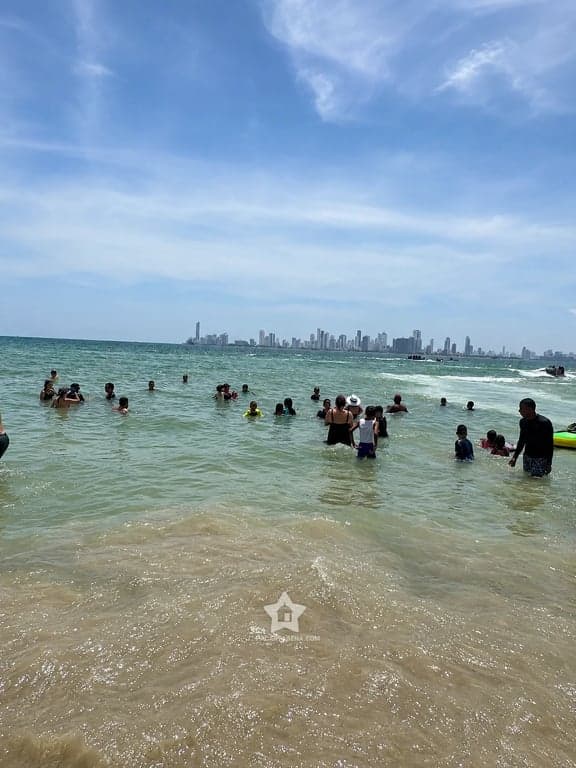 Bañistas en el mar de Punta Arena con el skyline de Cartagena al fondo, a 10 minutos en lancha