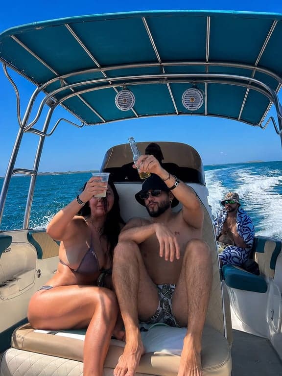 Tu grupo a bordo del bote privado a Cholón: brindis bajo el toldo con el capitán al timón