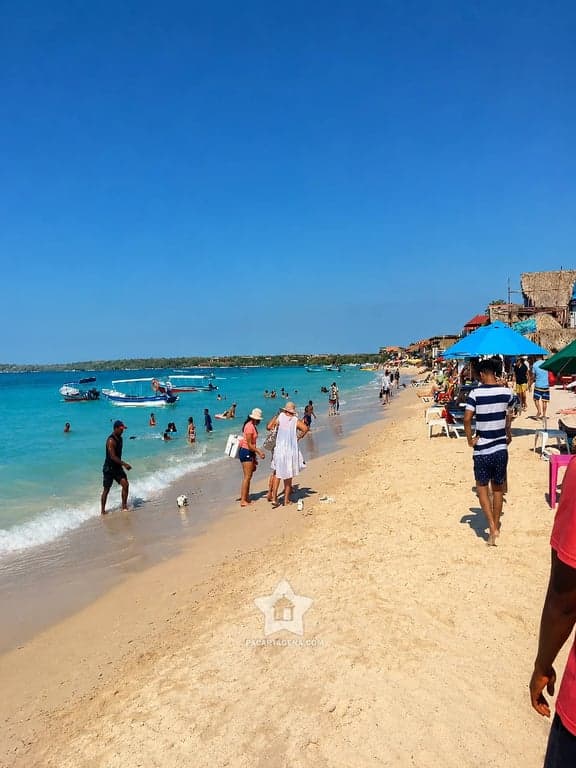 Ambiente de playa con bañistas y sombrillas en Playa Blanca, Barú