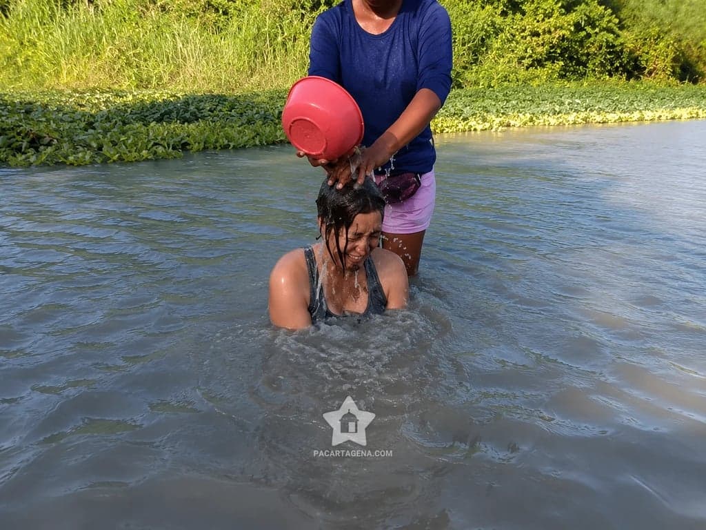 Las lavanderas enjuagan el lodo con totuma en la Ciénaga del Totumo