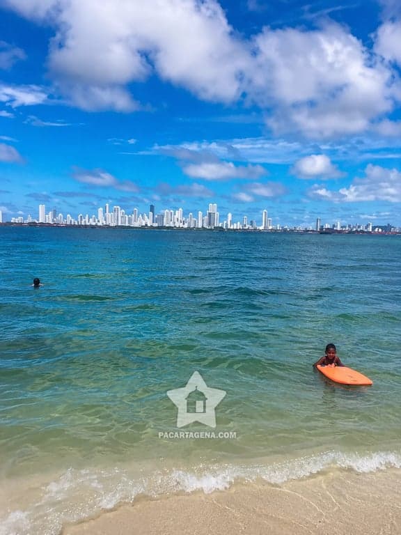 Bañistas en Punta Arena frente al skyline de Cartagena, en la isla de Tierra Bomba