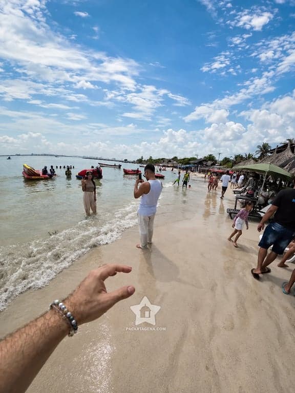 Ambiente de playa con bañistas y lanchas en Punta Arena, Tierra Bomba