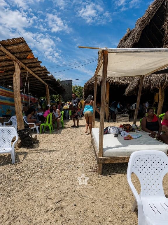 Camas y sillas bajo los kioscos de palma de Bongo, en la playa de Punta Arena