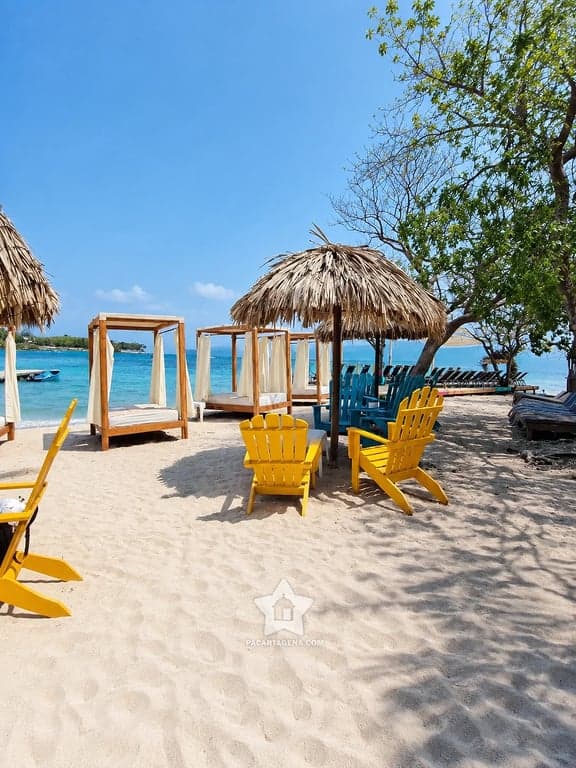 Club de playa con sillas y choza de palma a la orilla del mar, isla del archipiélago del Rosario
