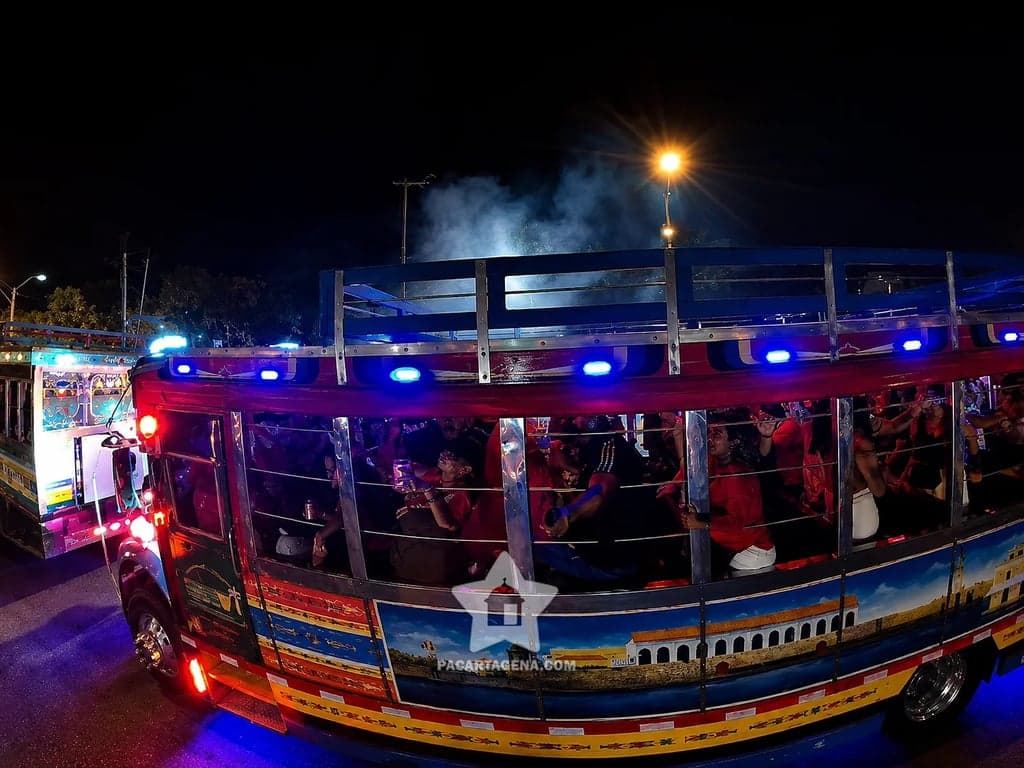 Chiva rumbera llena de gente y luces LED recorriendo Cartagena de noche