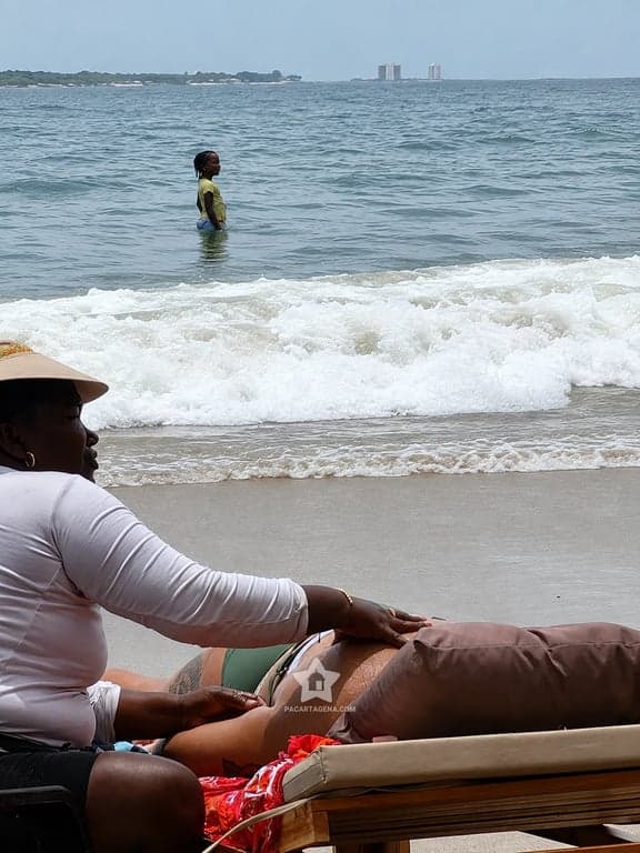 Masaje a pie de playa en Nakawa Beach Club, con la orilla y el perfil de Cartagena al fondo
