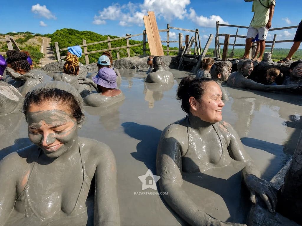 Dos viajeras con el rostro cubierto de lodo mineral sonríen en el Volcán del Totumo