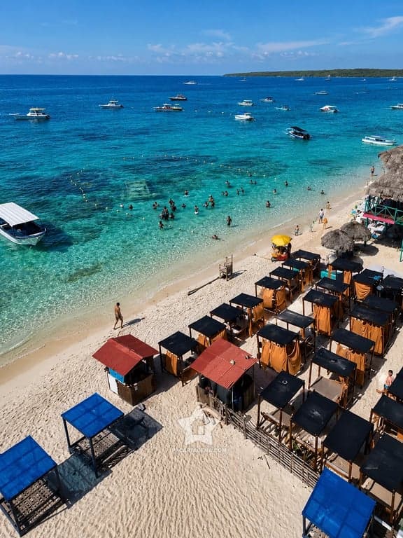 Playa turquesa de las Islas del Rosario con lanchas y carpas, parada del tour 4 islas
