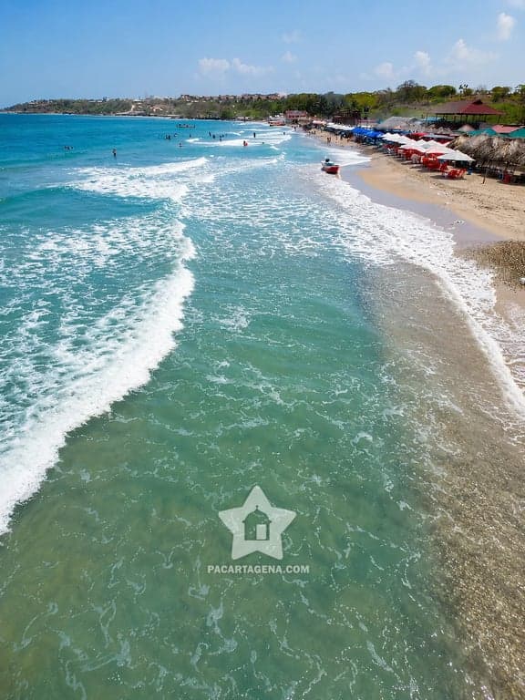 Playa Linda en Tierra Bomba: carpas de paja y olas en un sector de playa semipúblico