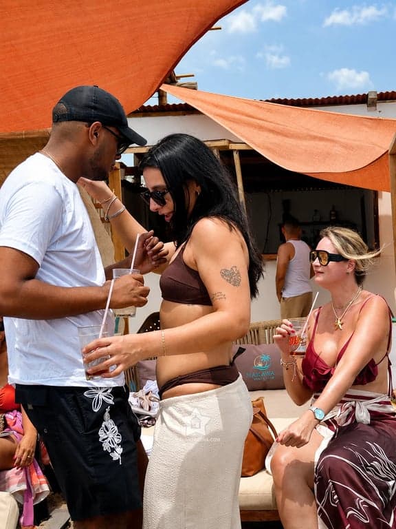 Zona de bar del Nakawa Beach Club, con techos de caña, velas de sombra y visitantes con bebidas