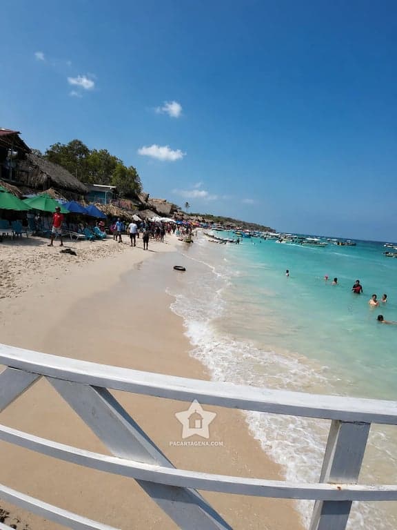 Quioscos de palma a la orilla de Playa Blanca en Barú, playa concurrida cerca de Cartagena