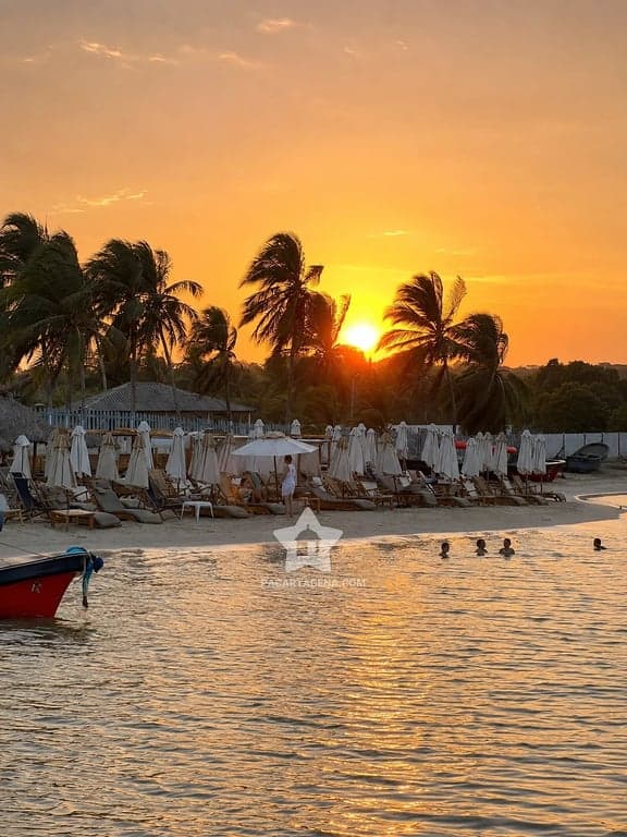 Atardecer sobre el mar desde Palmarito, con camastros y lancha en la orilla