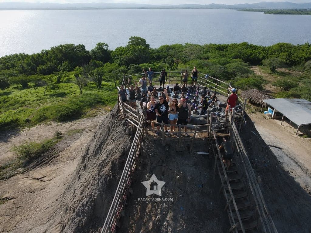 Grupo de viajeros en la cima del Volcán del Totumo con la Ciénaga del Totumo de fondo